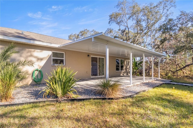 rear view of property featuring a lawn and a patio