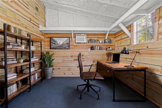 carpeted office with wooden walls, a wall unit AC, and lofted ceiling