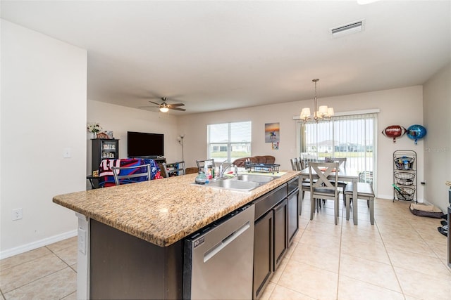 kitchen featuring decorative light fixtures, light tile patterned flooring, a kitchen island with sink, and dishwasher