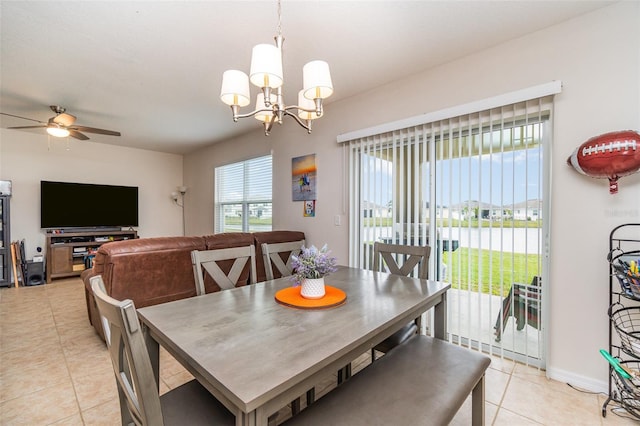 dining area with ceiling fan with notable chandelier and light tile patterned floors