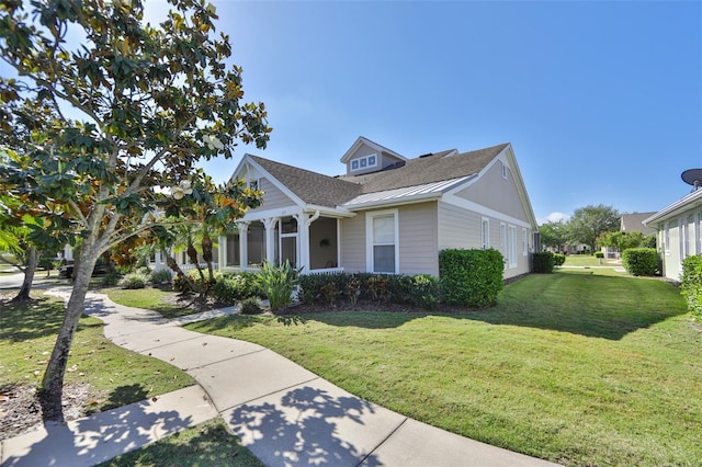 view of front of house featuring a front lawn and metal roof