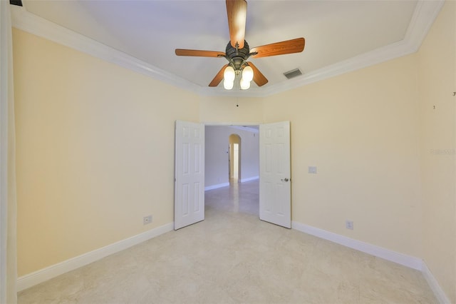 spare room featuring arched walkways, ornamental molding, visible vents, and baseboards