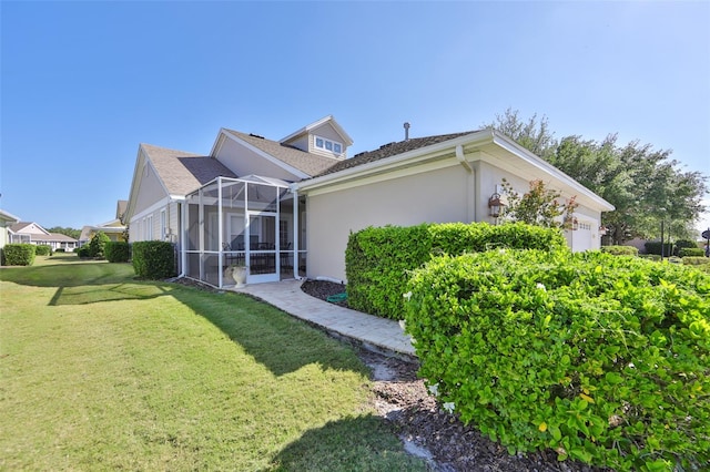 view of home's exterior with a garage, a lawn, a lanai, and stucco siding