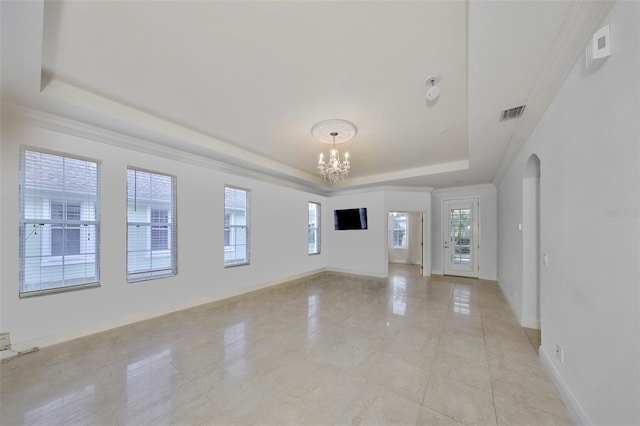 spare room with a raised ceiling, visible vents, arched walkways, baseboards, and a notable chandelier