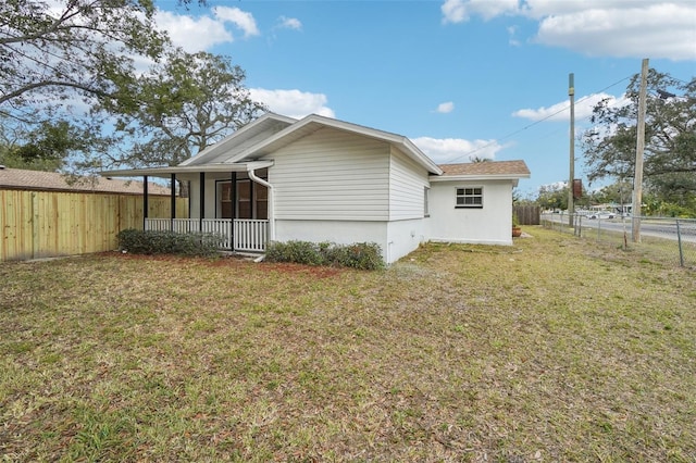 back of property with covered porch and a lawn