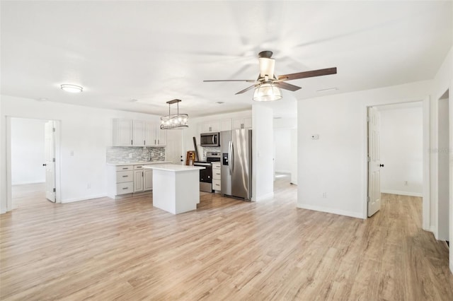 kitchen featuring white cabinetry, stainless steel appliances, a center island, tasteful backsplash, and decorative light fixtures