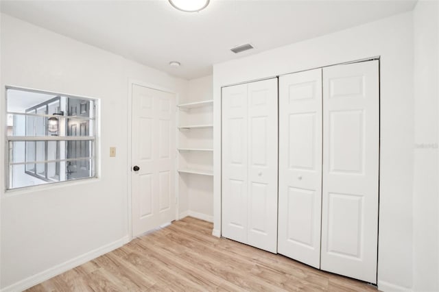 unfurnished bedroom featuring light hardwood / wood-style floors and a closet