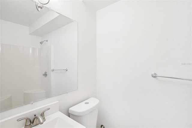 bathroom featuring a shower, sink, and toilet