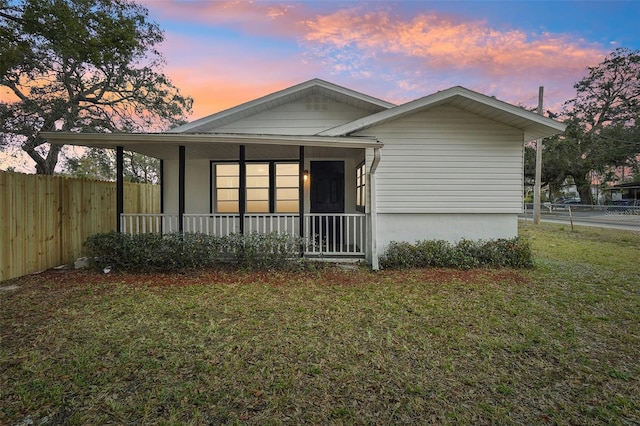 view of front of house featuring a lawn and covered porch