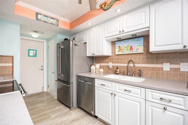 kitchen featuring sink, white cabinets, appliances with stainless steel finishes, and crown molding