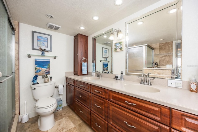 bathroom featuring a shower with door, a textured ceiling, toilet, and vanity