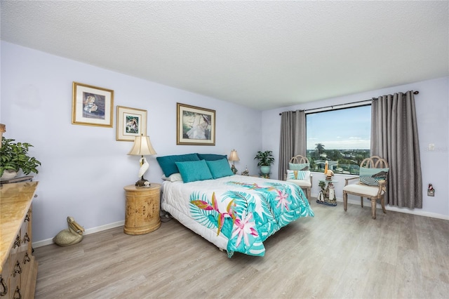 bedroom with light hardwood / wood-style floors and a textured ceiling