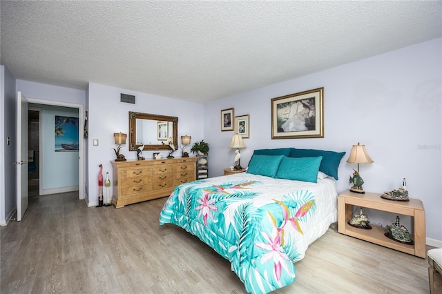 bedroom featuring hardwood / wood-style flooring and a textured ceiling