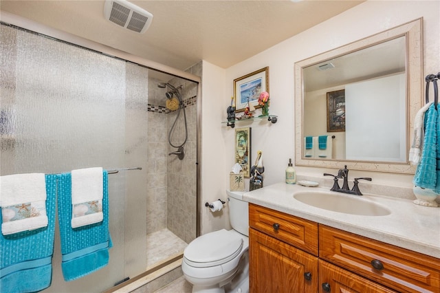 bathroom featuring toilet, a shower with shower door, and vanity