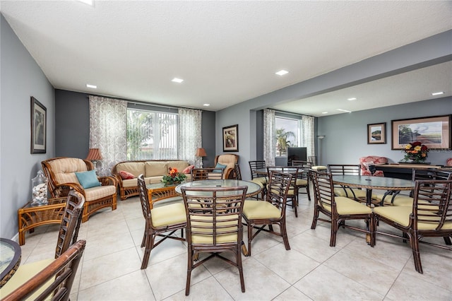 dining area with a textured ceiling and light tile patterned floors