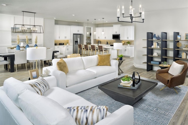 living room with light wood-type flooring and a chandelier