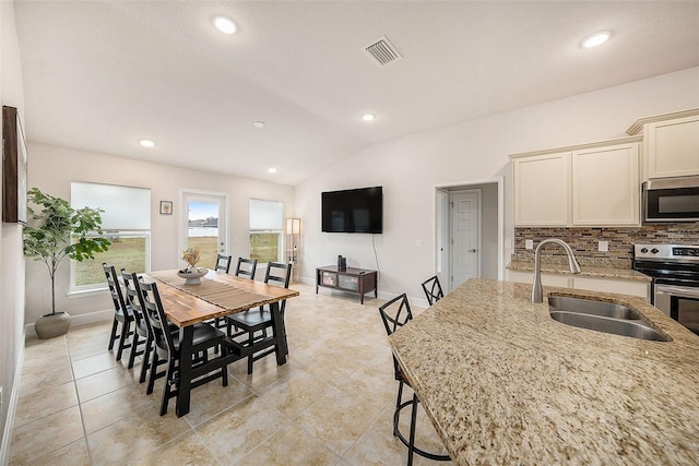 dining area with sink and lofted ceiling