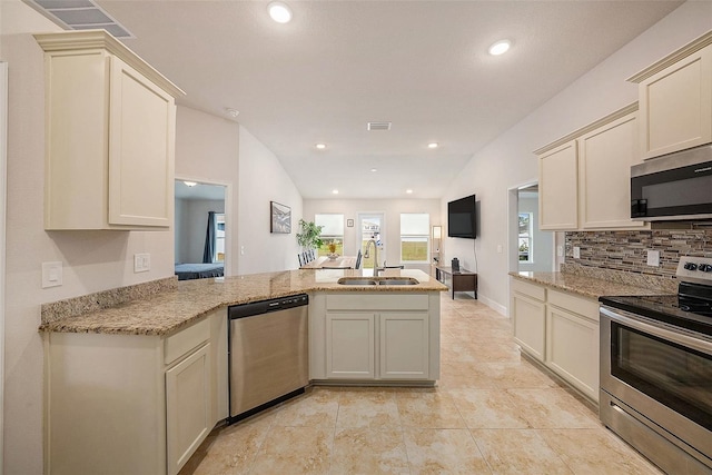 kitchen with sink, cream cabinetry, kitchen peninsula, and appliances with stainless steel finishes