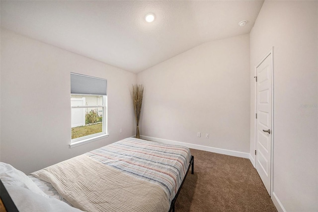 bedroom with dark carpet and vaulted ceiling