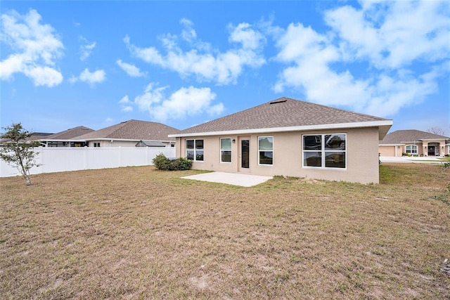 rear view of house with a lawn and a patio