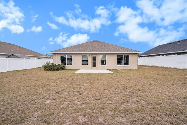 rear view of house featuring a lawn and a patio