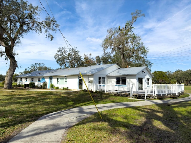 single story home with a deck and a front yard