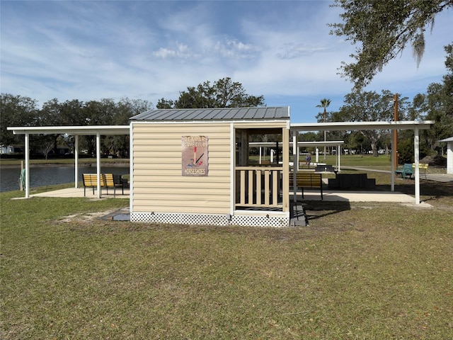 view of outdoor structure with a yard and a water view