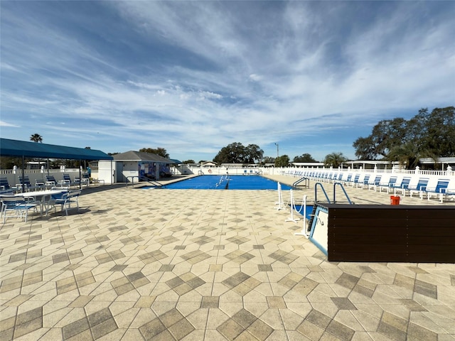 community pool featuring a patio area and fence