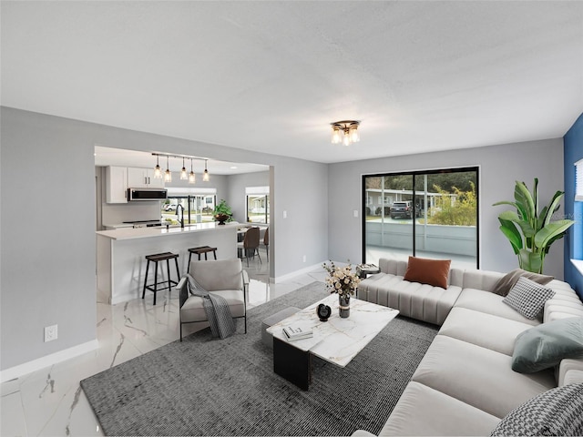 living area featuring marble finish floor and baseboards