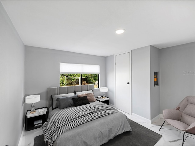 bedroom featuring marble finish floor and baseboards