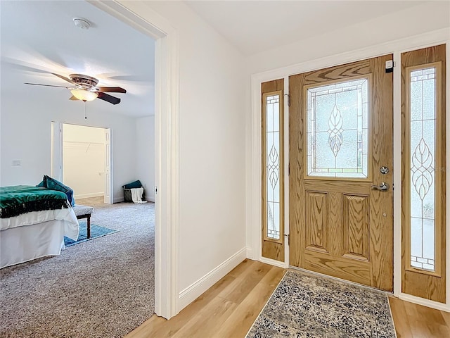 carpeted entryway with a wealth of natural light and ceiling fan