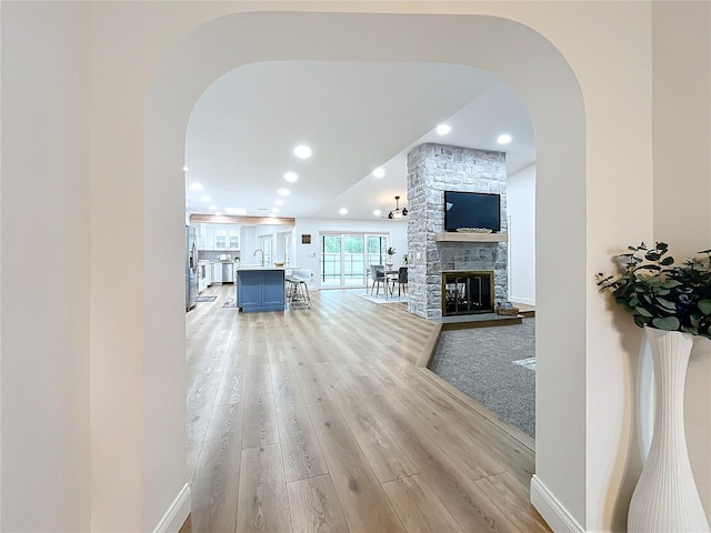 living room with sink, a fireplace, and light hardwood / wood-style floors