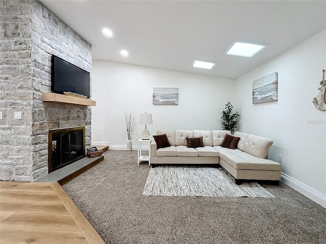 living room featuring lofted ceiling, a fireplace, and carpet floors