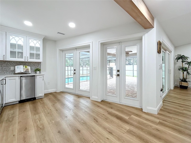 entryway with french doors, beamed ceiling, and light wood-type flooring