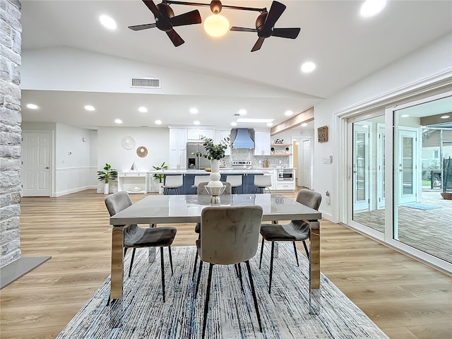 dining area with vaulted ceiling and light hardwood / wood-style flooring