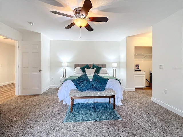 bedroom featuring carpet floors, a spacious closet, ceiling fan, and a closet