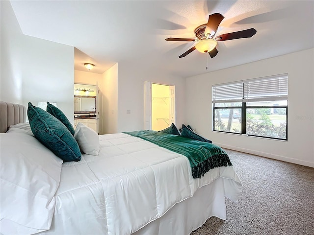 carpeted bedroom featuring ceiling fan and ensuite bathroom