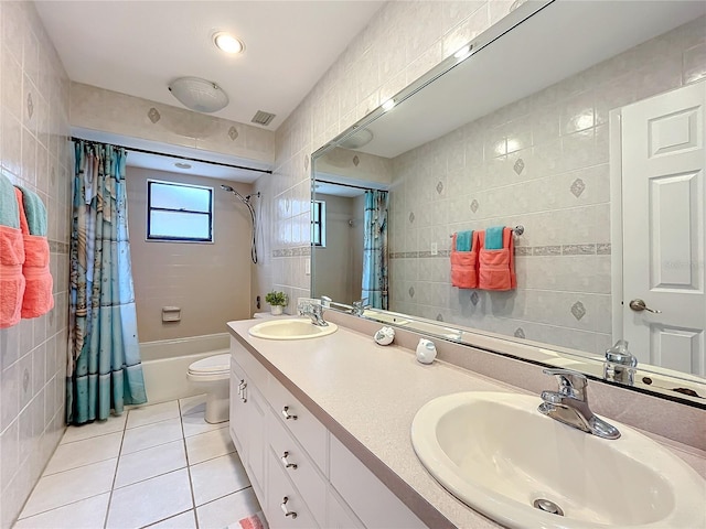 full bathroom with tile walls, tile patterned floors, shower / bath combination with curtain, and toilet