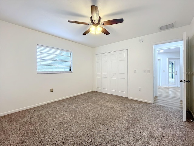 unfurnished bedroom with carpet floors, a closet, and ceiling fan