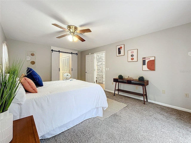 bedroom featuring a barn door, carpet floors, and ceiling fan