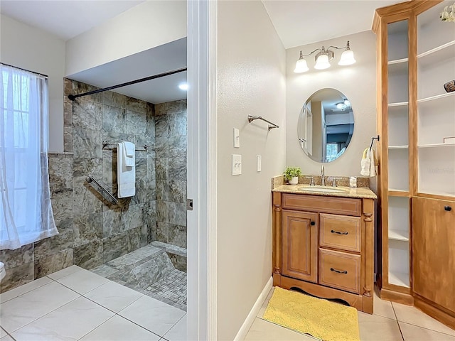 bathroom with tile patterned flooring, vanity, and tiled shower