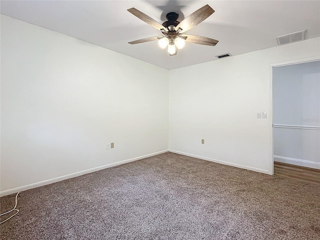 spare room with dark carpet and ceiling fan