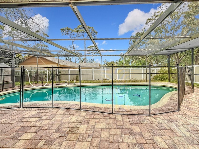 view of swimming pool featuring a lanai and a patio