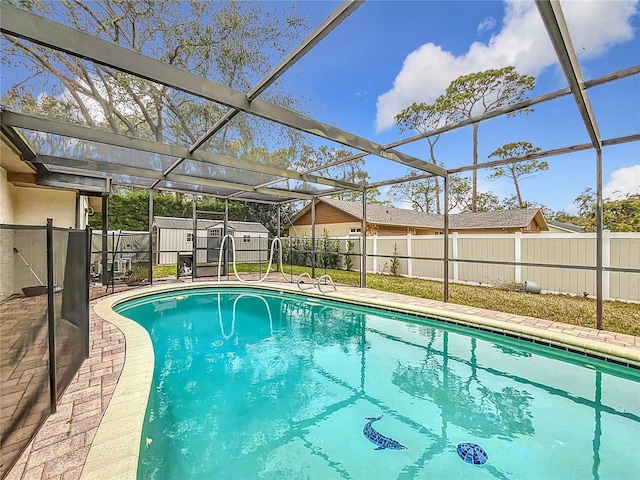 view of swimming pool with a storage shed and a lanai