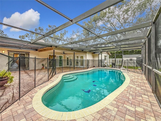 view of pool with ceiling fan, a lanai, and a patio