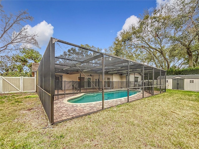 view of pool featuring a lanai, a patio area, a lawn, and a storage unit