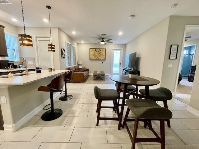 tiled dining area with sink and ceiling fan