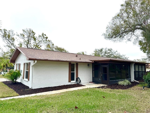 view of front facade with a front lawn and a sunroom