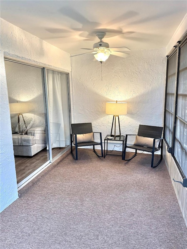 living area featuring ceiling fan and carpet floors