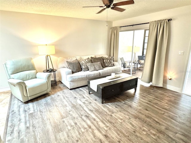 living room with ceiling fan, hardwood / wood-style floors, and a textured ceiling